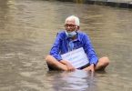 Man sits in the water to protest waterlogging