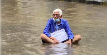 Man sits in the water to protest waterlogging