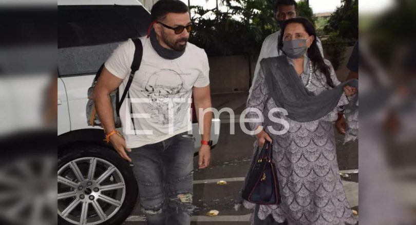 Dharmendra Prakash's wife looks at the airport